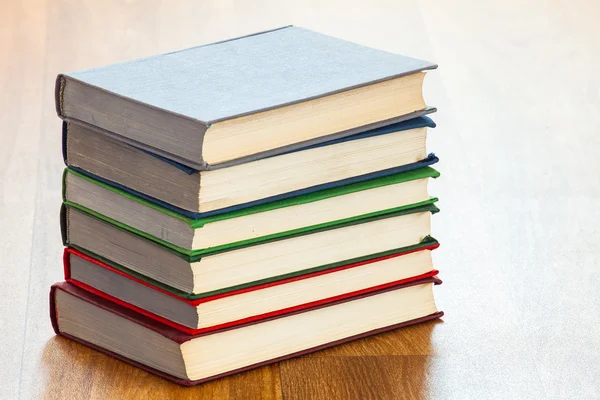 De leugenachtige multi-gekleurde boeken op een houten tafel. — Stockfoto