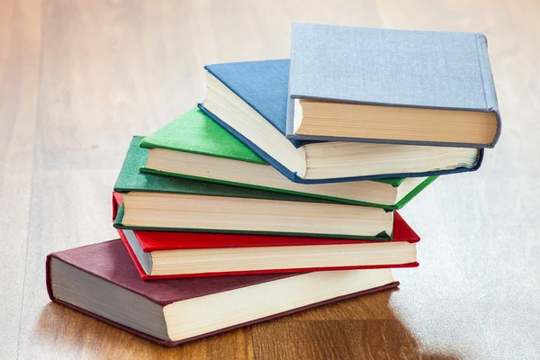 De leugenachtige multi-gekleurde boeken op een houten tafel. — Stockfoto