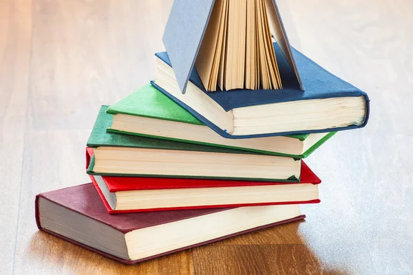De leugenachtige multi-gekleurde boeken op een houten tafel. — Stockfoto