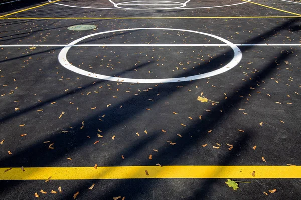 アスファルトターマックとマーキングフィールド上の円のバスケットボールエリア コピースペースと遊び場に太陽光で照らされたスポーツ — ストック写真