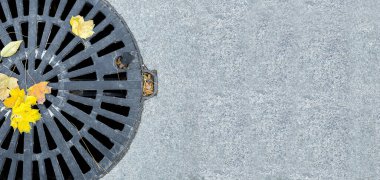 Rögar kapağı gelişen şehir kaldırımlarından oluşan siyah metal kafes granit gri fayanslarla döşenmiş sonbahar sezonu yakın çekimli, kopyalanmış sarı yapraklı, hiç kimse.
