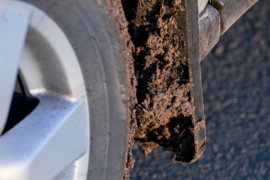 Kirli araba çamurluğu ön tekere sıçramış. Çamur yakın plan, lastik ve 4x4, kimse yok..