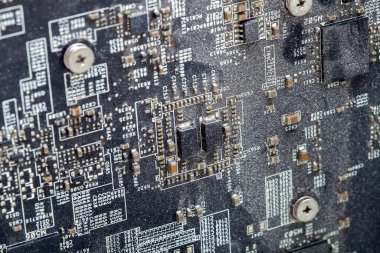 Baskılı devre kartının kirli çipleriyle kaplı yüzeyi aşırı ısınma ve bilgisayarın arızasına neden olur. Temizlenmemiş bir ana kartın yakın plan görüntüsü..