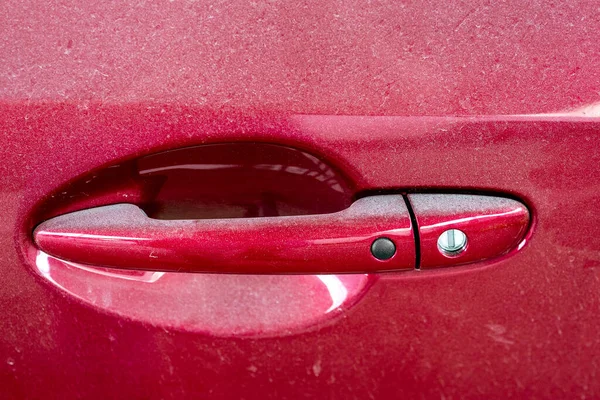 red door with handle and a keyhole and smart keyless access button close-up, abandoned dirty car covered with a layer of dust, nobody.
