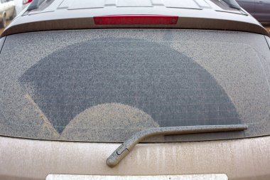 car rear window covered with a layer of swamp after the rain closeup of the trunk lid of a dirty suv, nobody.