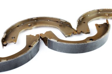 Çelik araba yedek parçalarının üzerinde asbest alaşımlı dört varil fren ayakkabısı beyaz arka planda izole edilmiş, kimse yok..