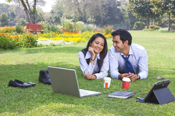 Zakenman en zakenvrouw werken in een park — Stockfoto