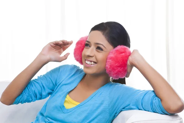 Mulher sorrindo usando abafadores de ouvido — Fotografia de Stock