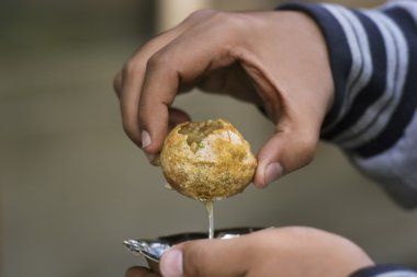 adam holding panipuri bir kasede servis