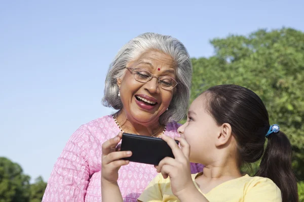 Großmutter und Enkelin mit Handy — Stockfoto