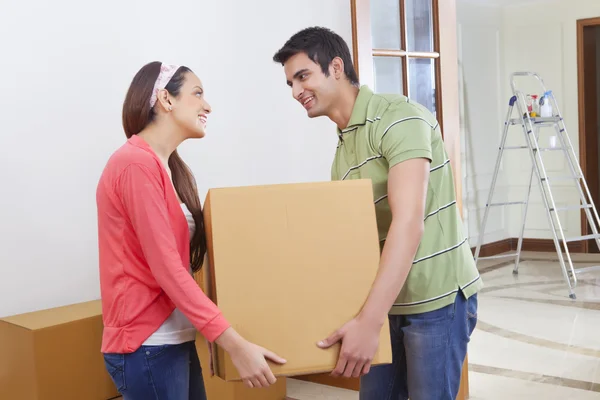 Мужчина и молодая женщина несут коробку — стоковое фото