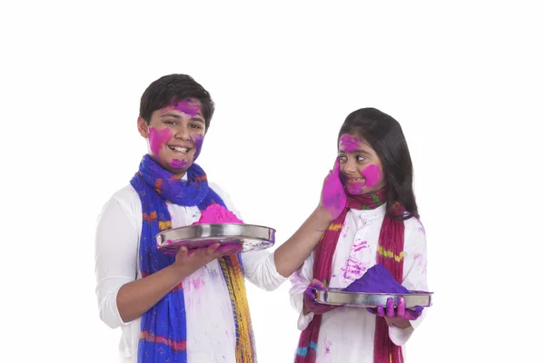 Boy putting holi colour on a girl — Stock Photo, Image