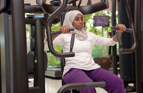 Joven árabe musulmana mujer forjado a cabo en un gimnasio Imagen De Stock