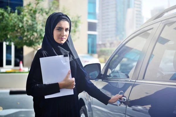 Emarati Arap iş kadını arabanın içine alma — Stok fotoğraf