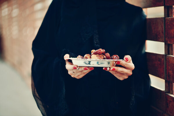 Арабская женщина Эмарати держит табличку с датами
