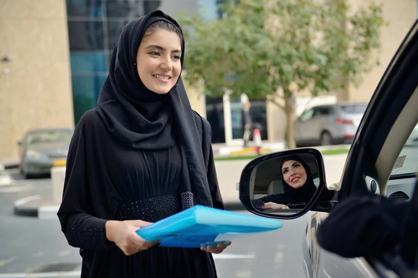 Emarati arabo affari donne ottenere in il auto Immagine Stock