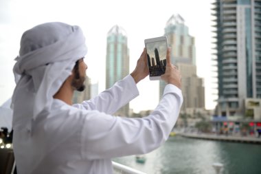 Young Emirati arab man taking photo clipart