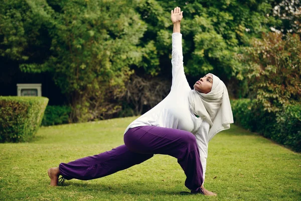 Arap kadın havuz tarafından yoga yaparken