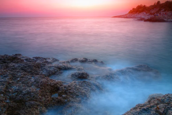 Salida del sol sobre la playa rocosa — Foto de Stock