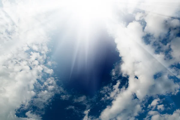 The flare of the sun in the sky with white clouds — Stock Photo, Image