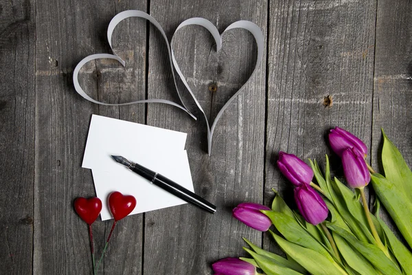 Tulips pen and white card on wooden background — Stock Photo, Image