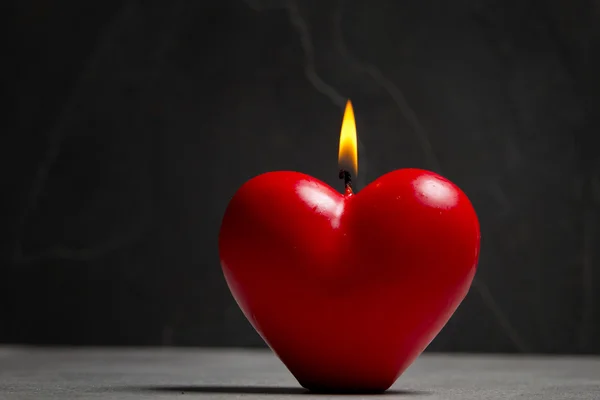 Candle in heart shape on stone background — Stock Photo, Image