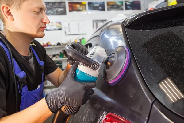 Trabalhador Uma Oficina Reparação Automóveis Detém Uma Máquina Polir Luvas — Fotografia de Stock