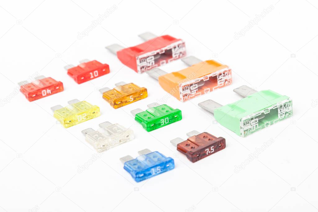 Colorful set of electronic fuses in yellow green orange red and blue on a white isolated background in a photo studio of a car electrical circuit protection device for sale or repair in auto service.