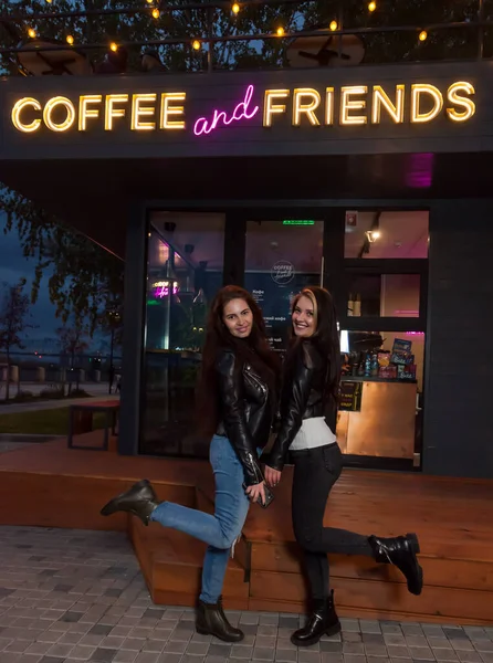 Две Молодые Студентки Лучшие Подруги Стоят Набережной Фоне Кофейни Неоновой — стоковое фото