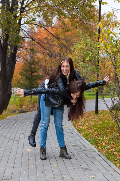 Две Юные Студентки Гуляют Парке Веселятся Валяясь Спине Друга Фоне — стоковое фото
