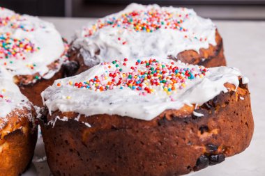 Ev mutfağındaki bir tabaktaki kuru üzümlü taze kaymak hamuruna yakın plan - beyaz jöleli yumurta beyazı, renkli konfeti ile süslenmiş - bir sürü renkli top.