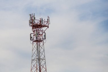 Altai dağlarında erişilemez bir yerde kırmızı-beyaz metalden yapılmış bir baz istasyonu. Telsiz dalgaları üzerinden sinyal iletmek için yeşil kozalaklı ağaçların arka planına karşı..