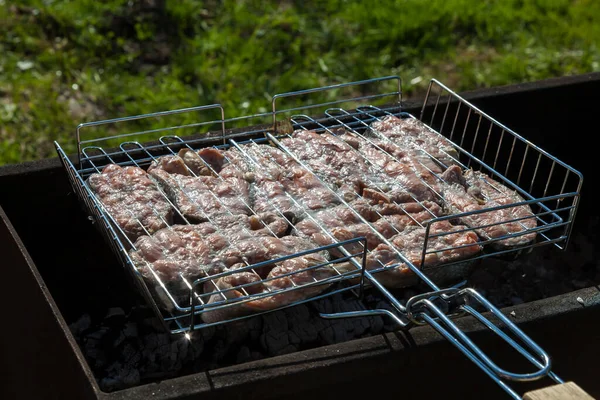 Top view of the browned steaks of red coho salmon fried on charcoal in a barbecue on a summer day in the country. Cooking a wholesome outdoor grill dinner. — Stock Image Top View Browned Steaks Red Coho Salmon Fried Charcoal Barbecue Royalty Free Stock Photos