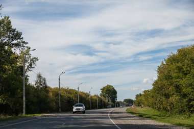 Yaz günü Altai Dağları 'nda yol tepelerin ve ağaçların arasından geçen yeşil kozalaklı ormanın arka planına karşı. Doğada şehir dışında tatil yaparken serbest yol..