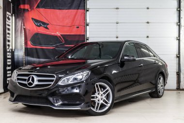 Novosibirsk, Rusya - 11.30.2020: Garaj kutusunda, yüzeydeki çizikleri temizlemek ve cilalamak için duran Mercedes E sınıfı bir arabaya yakın plan. Otomobil hizmet endüstrisi.