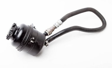 Yedek araba parçası. Katalog için beyaz izole edilmiş arka planda güç direksiyon yağı içeren plastik siyah bir tank kullanılmış. Atölyedeki otomatik ayrıştırmada ekipman onarımı.