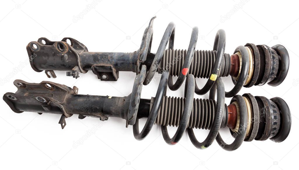 Two shock absorber struts with black springs after being used on a car during replacement and repair on a white isolated background. Used spare parts. Auto parts catalog.