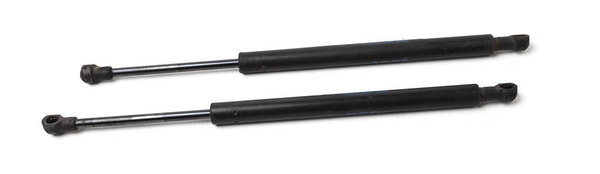 A pair of black metal hood shock absorbers with chrome elements - detail of a car mechanism on a white isolated background. Spare parts for body repair.