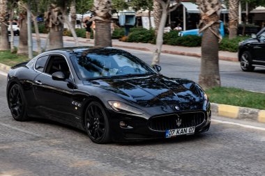 Kemer, Türkiye 08.31.2021: Siyah Maserati GranTurismo sıcak bir yaz gününde sokağa park etti