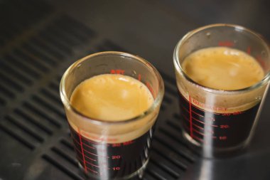 Krema kahve fincanını kapat kahve fincanına kahve makinası doldur tek bardakta ve kahveci kafede barista tarafından duble shot.