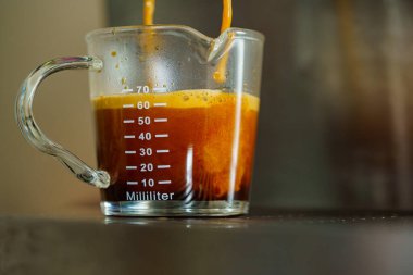 Kapat ve makro krema kahvesi shot kahve fincanının içine kahve fincanı dolduran kahve makinası tek bardakta ve kahveci kafede barista tarafından duble shot.