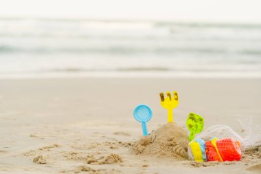 Çocuk oyuncakları yaz kumsalında toplanıyor ve tatil ve tatil için kumsalda toplanıyor. Plastik oyuncak kovası ve kum havuzu kalıpları. Sahilde ve denizde.