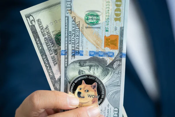 Dogecoin coin DOGE included with Cryptocurrency and stack 100 hundred new US dollar Money American on hand business man wearing a blue suit. Filed and put and give to me.