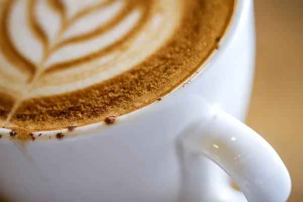 Zavřete makro snímek na horký Cappuccino s bílým cup na dřevo kartu — Stock fotografie