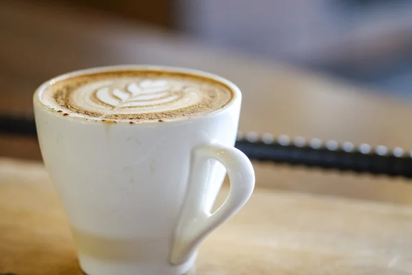 Cappuccino quente com copo branco na casa de café de mesa de madeira — Fotografia de Stock