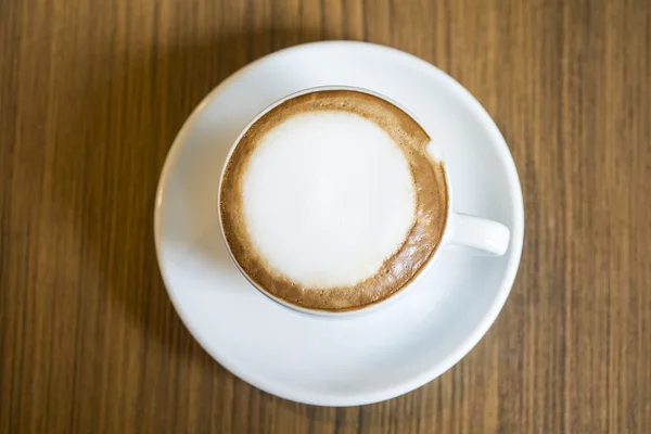 Cappuccino quente com copo branco na casa de café de mesa de madeira — Fotografia de Stock