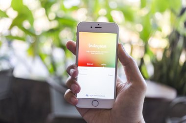 CHIANG MAI, THAILAND - JANUARY 02, 2015: A man trying to log in Instagram application using Apple iPhone 6. Instagram is largest and most popular photograph social networking site in the world.