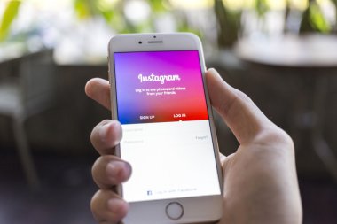CHIANG MAI, THAILAND - JANUARY 02, 2015: A man trying to log in Instagram application using Apple iPhone 6. Instagram is largest and most popular photograph social networking site in the world.