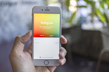 CHIANG MAI, THAILAND - JANUARY 02, 2015: A man trying to log in Instagram application using Apple iPhone 6. Instagram is largest and most popular photograph social networking site in the world.