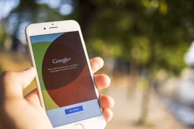 CHIANG MAI, THAILAND - JANUARY 04, 2015: Man hold Apple iphone 6 with Google+ social network of the Google company. Information of a social network, influences Google search results.